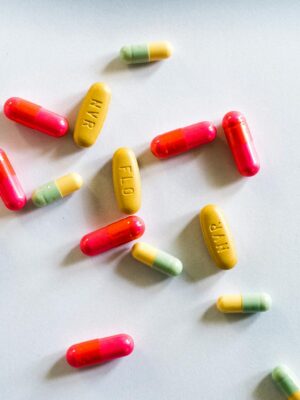 Colorful capsules and tablets scattered on a white surface, showcasing variety in medicines.