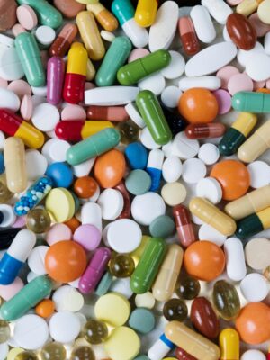 Vibrant assortment of medicine capsules and tablets in a flatlay format, highlighting diversity in pharmaceuticals.